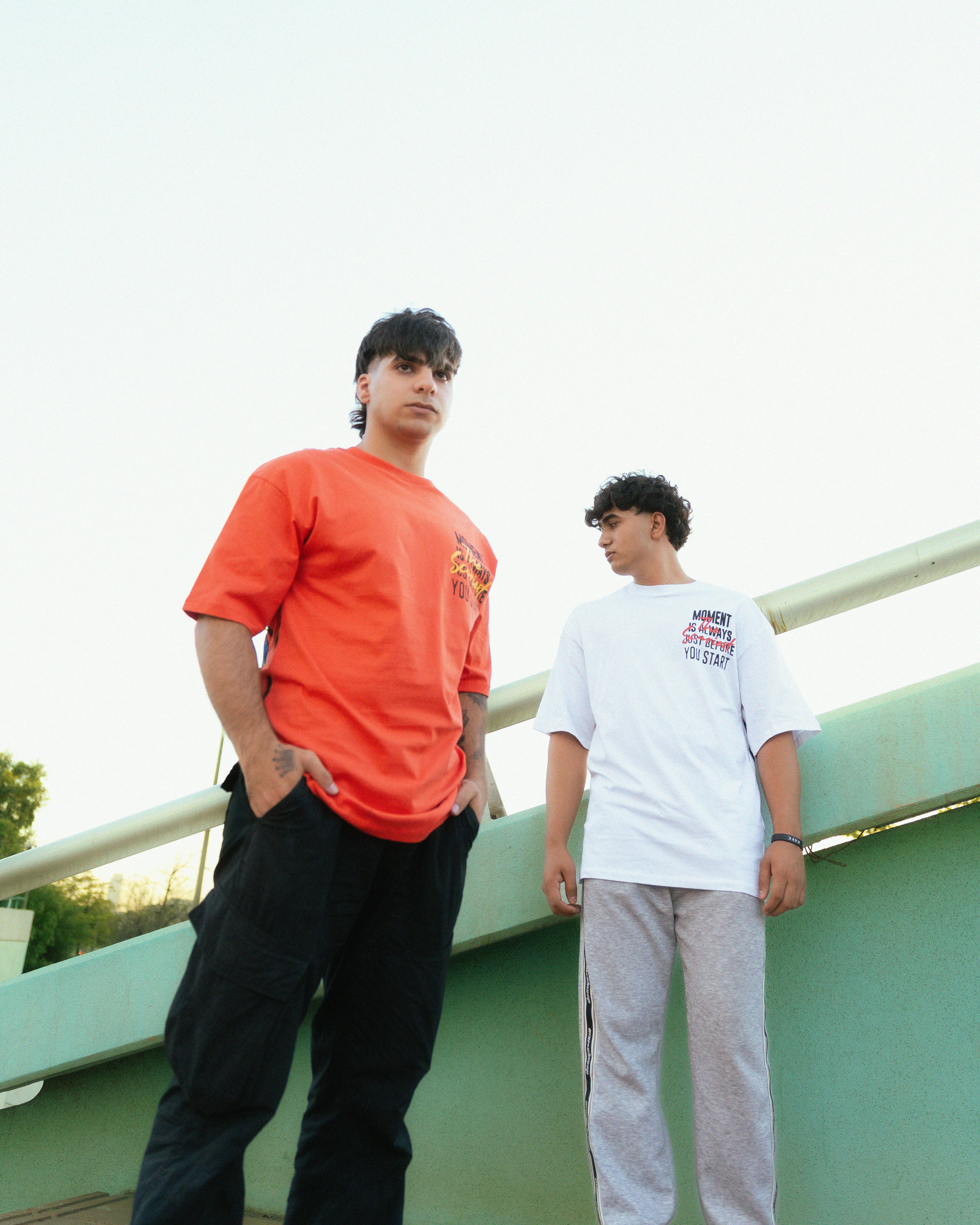 two young men standing on a bridge