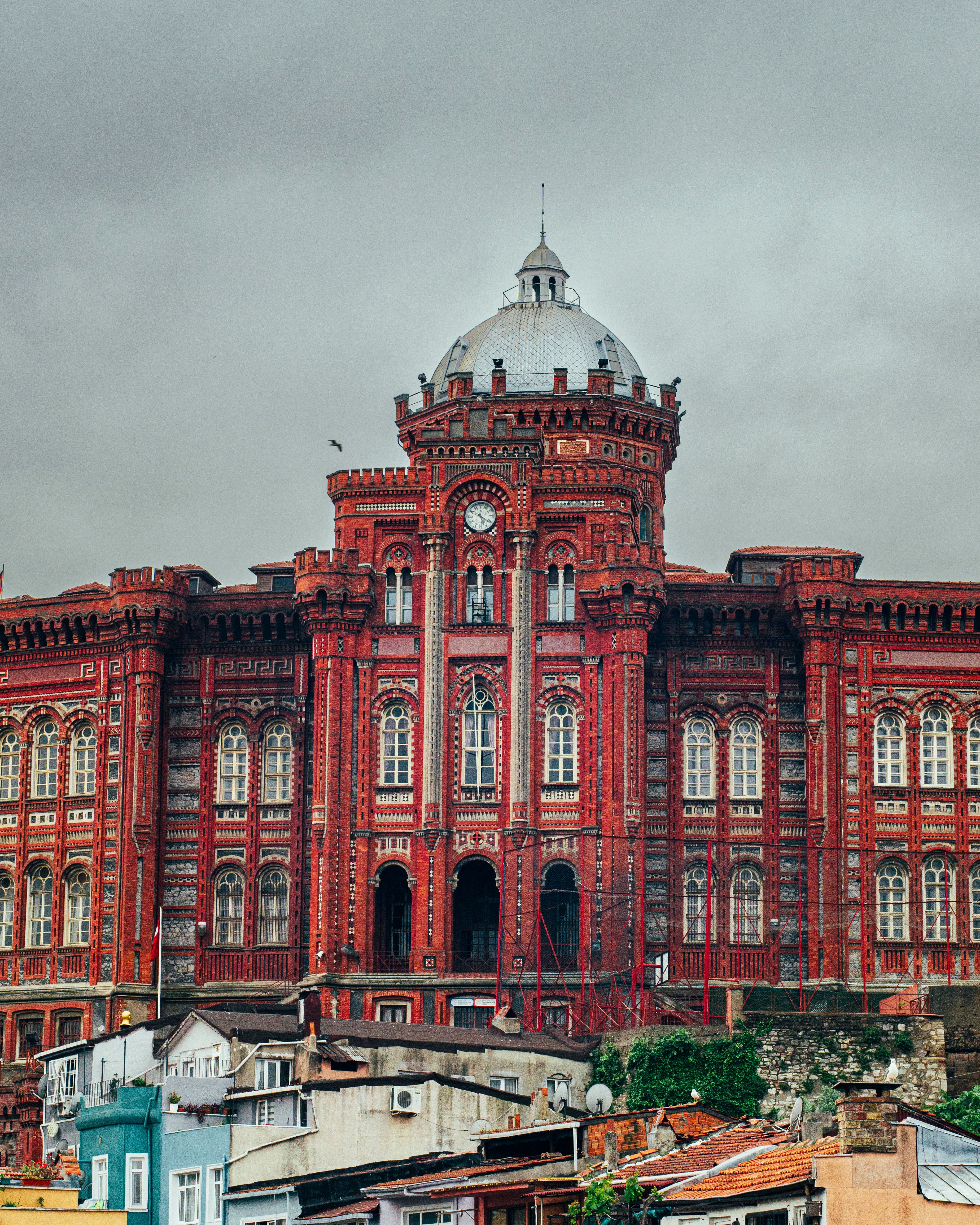 A large red building with a clock tower on top · Free Stock Photo
