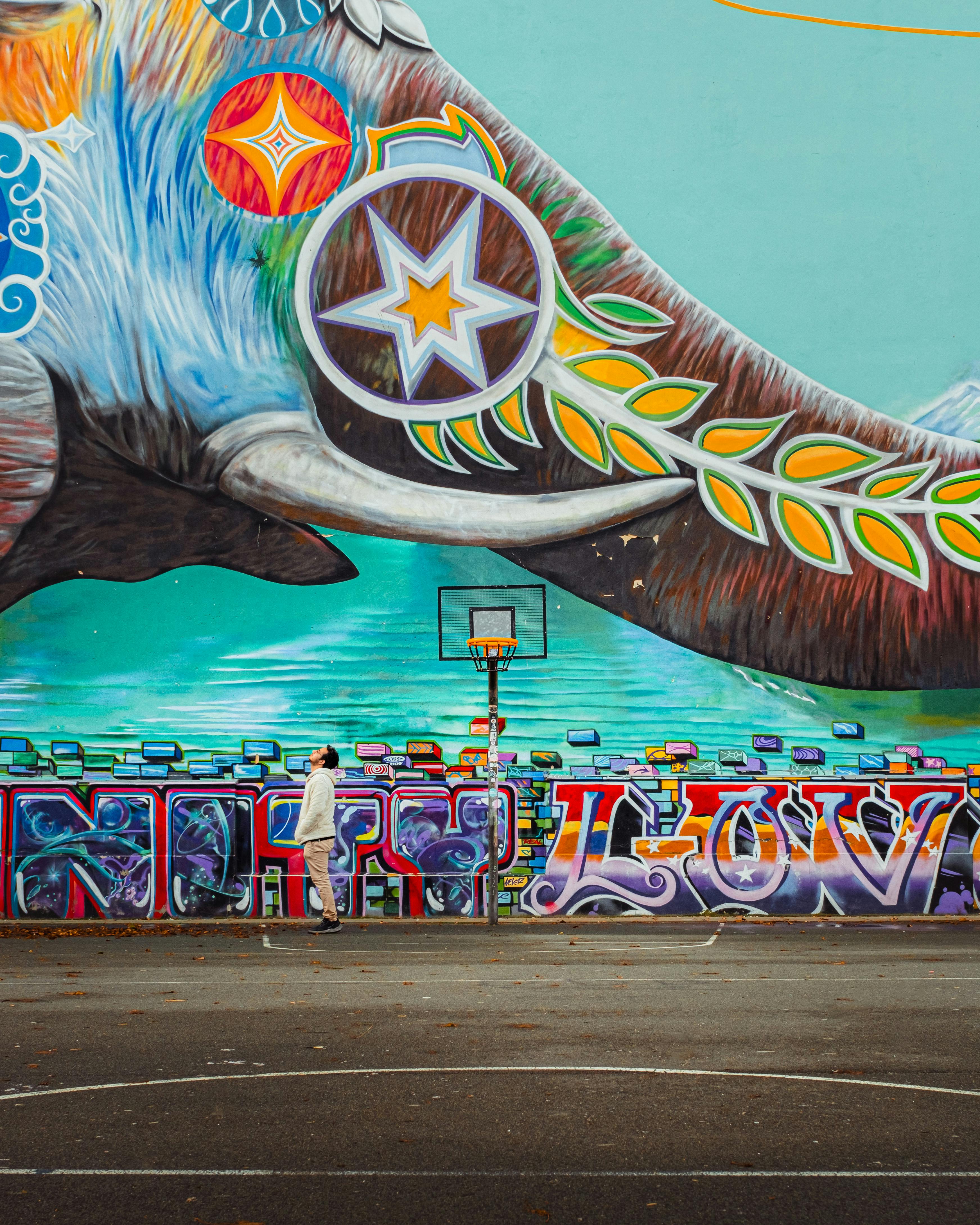 a man is standing in front of a mural of an elephant