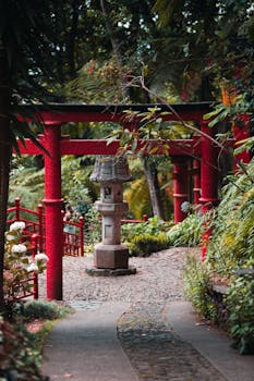 Peaceful Japanese-style garden with red torii gates and stone lantern in Madeira, Portugal.