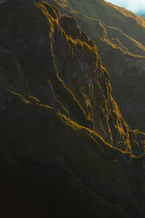 Free Captivating sunset light over rugged mountains in Madeira, Portugal. Stock Photo