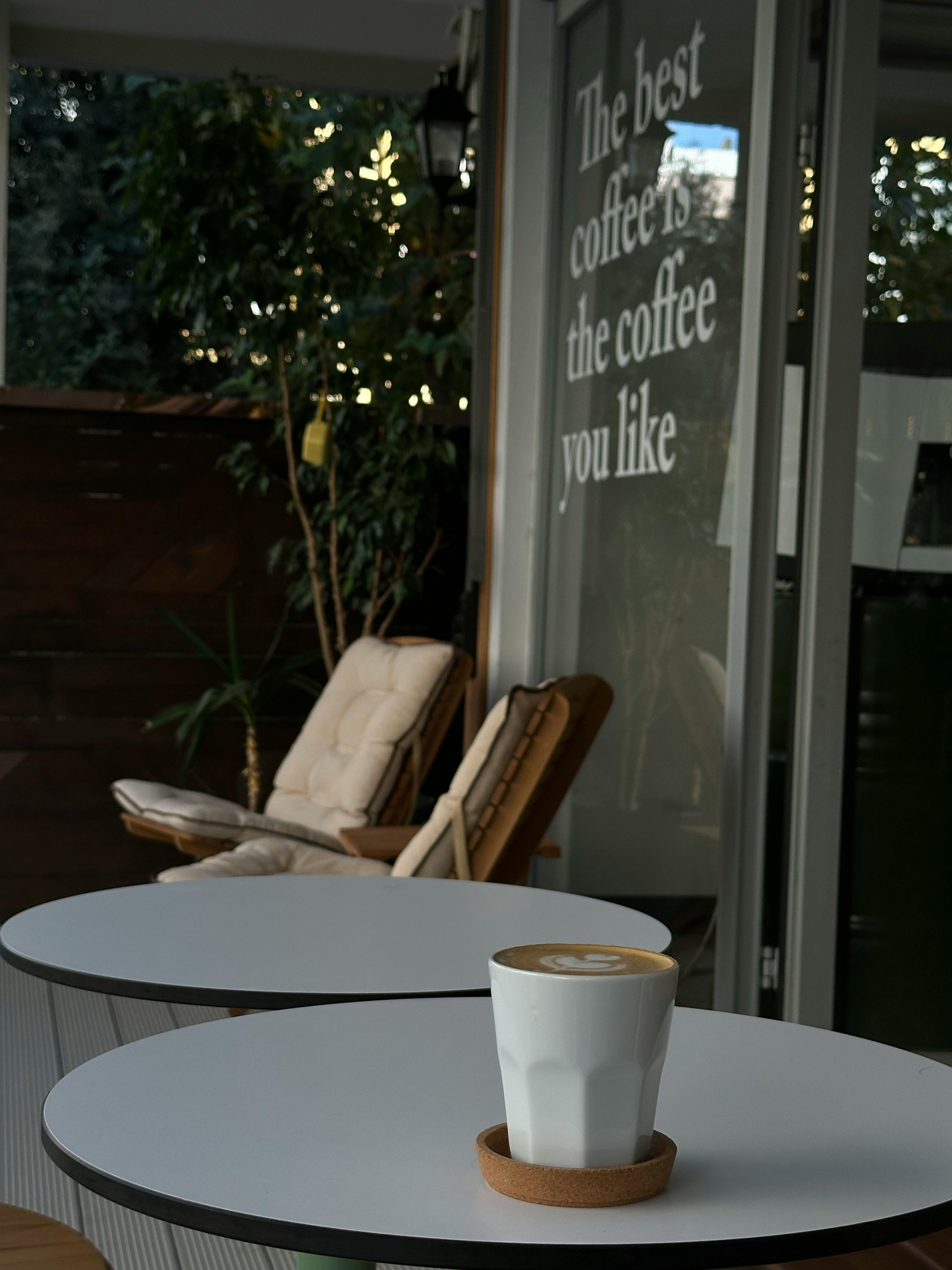 A cozy café in Antalya with a cappuccino and inspiring coffee quote.