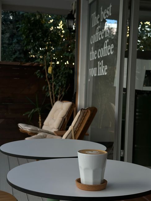 A cozy café in Antalya with a cappuccino and inspiring coffee quote.