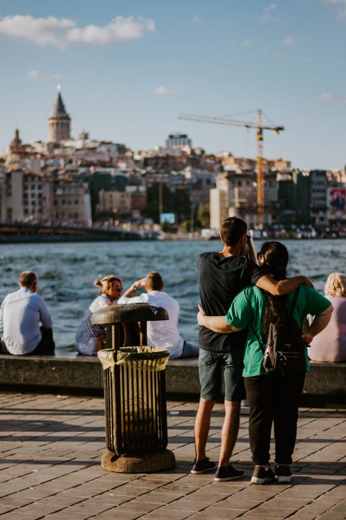 Free Couple embracing by the Bosphorus with Galata Tower in Istanbul's scenic landscape. Stock Photo