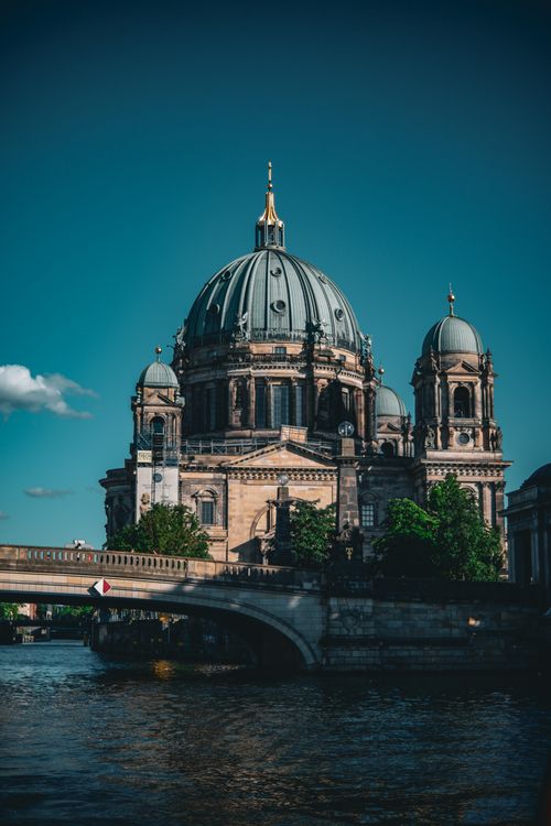 Free Capture of the majestic Berlin Cathedral with its iconic dome under a twilight sky, reflecting on the river. Stock Photo