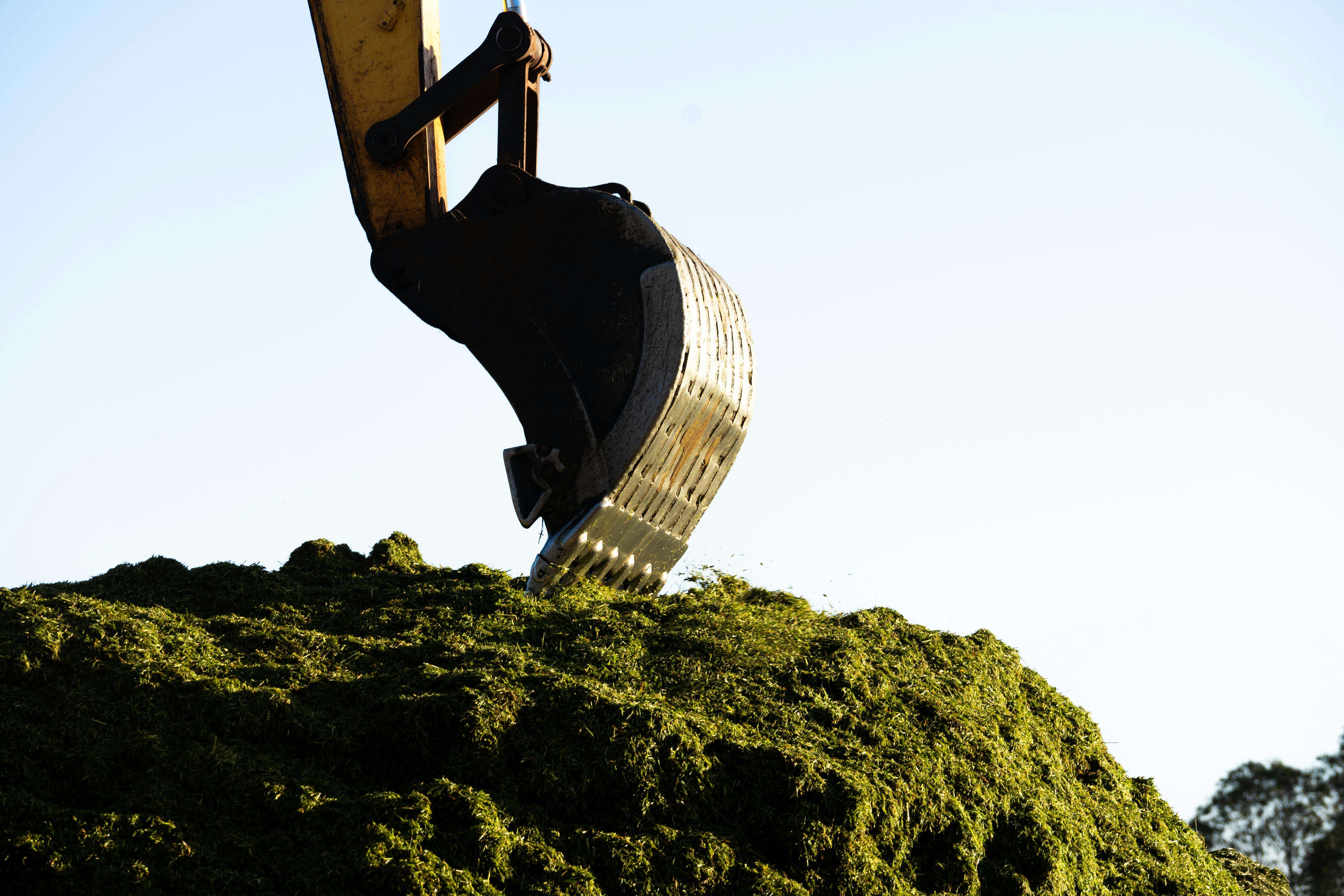 A bulldozer is digging up some grass