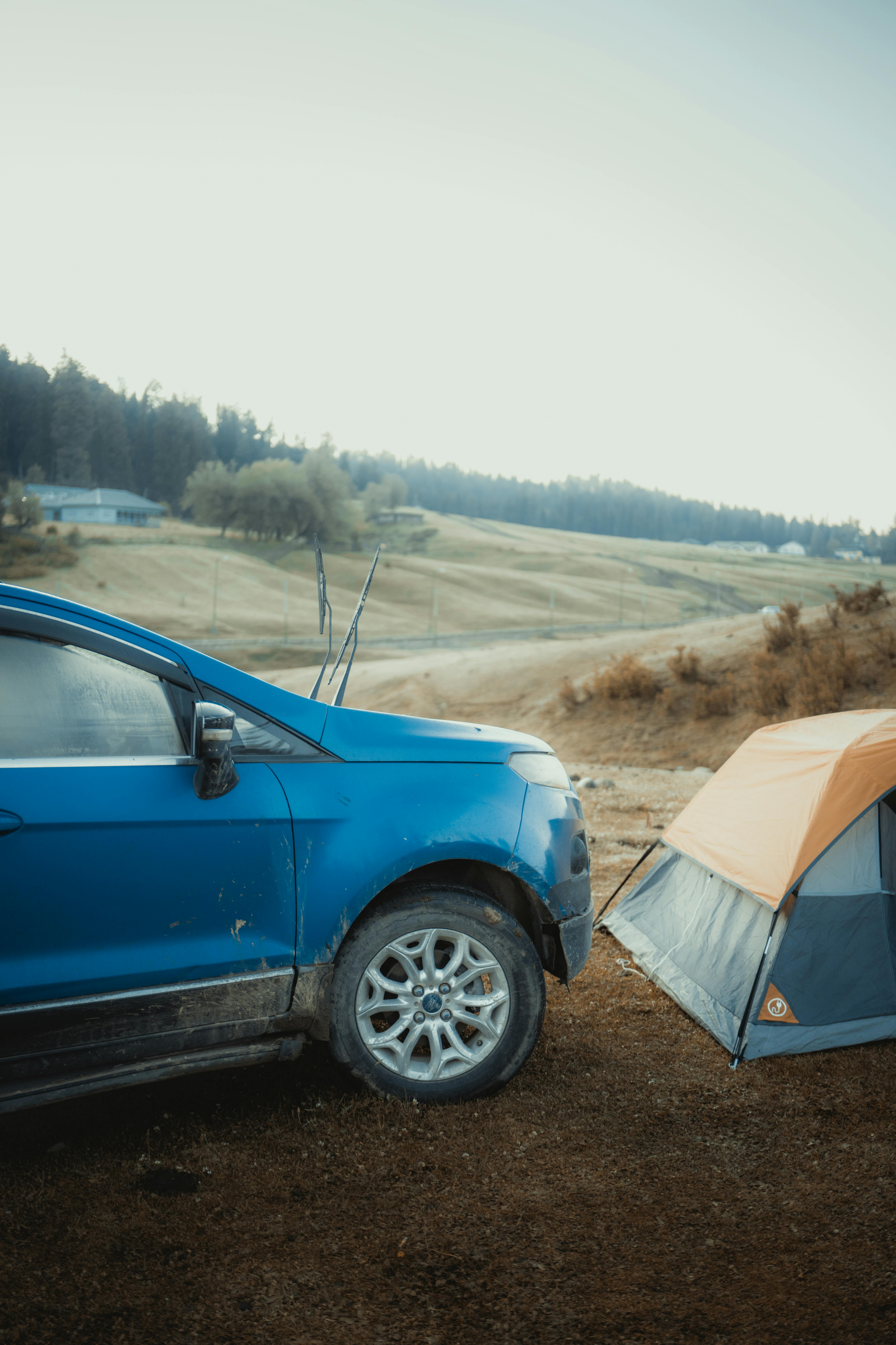 Wheelchair user relaxing at a campsite beside a tent and camp chair