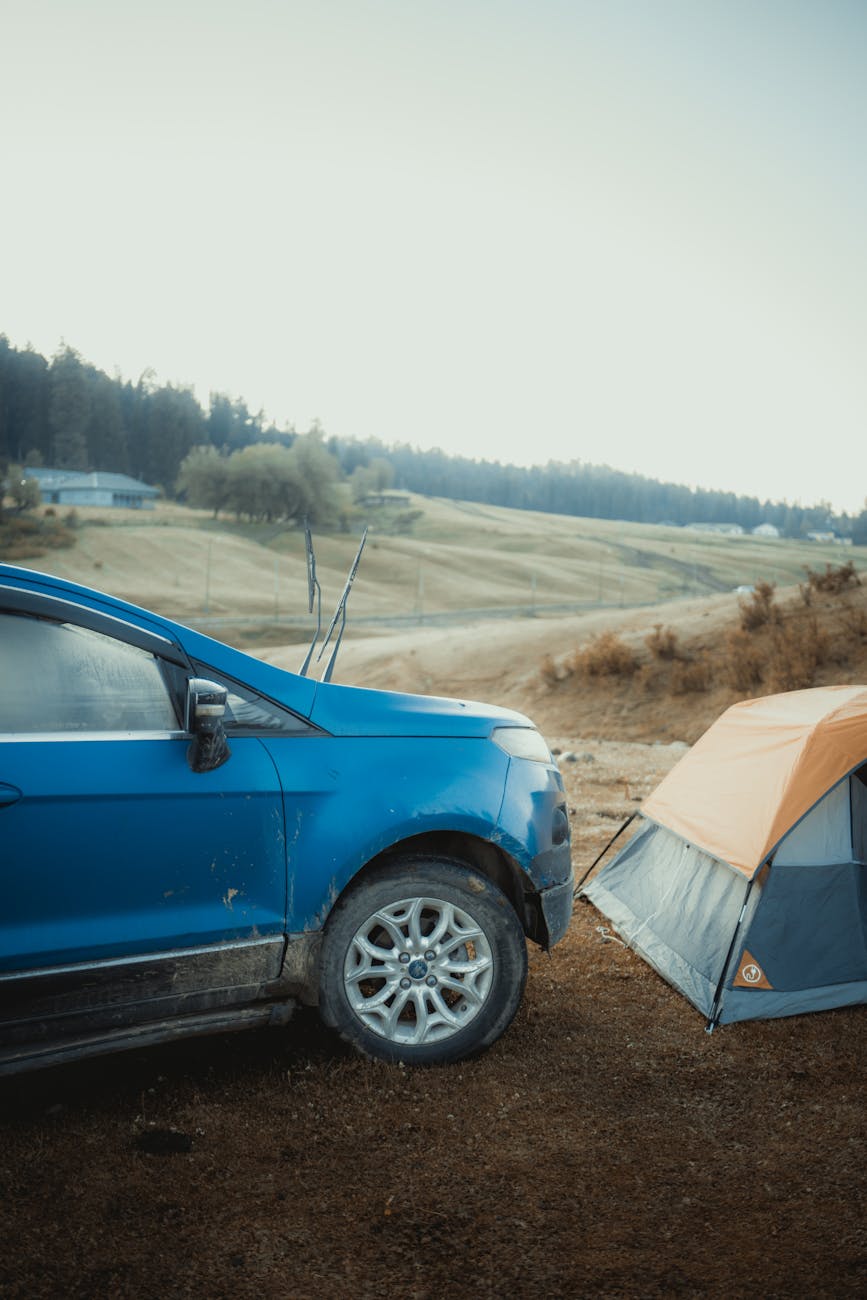 Wheelchair user relaxing at a campsite beside a tent and camp chair