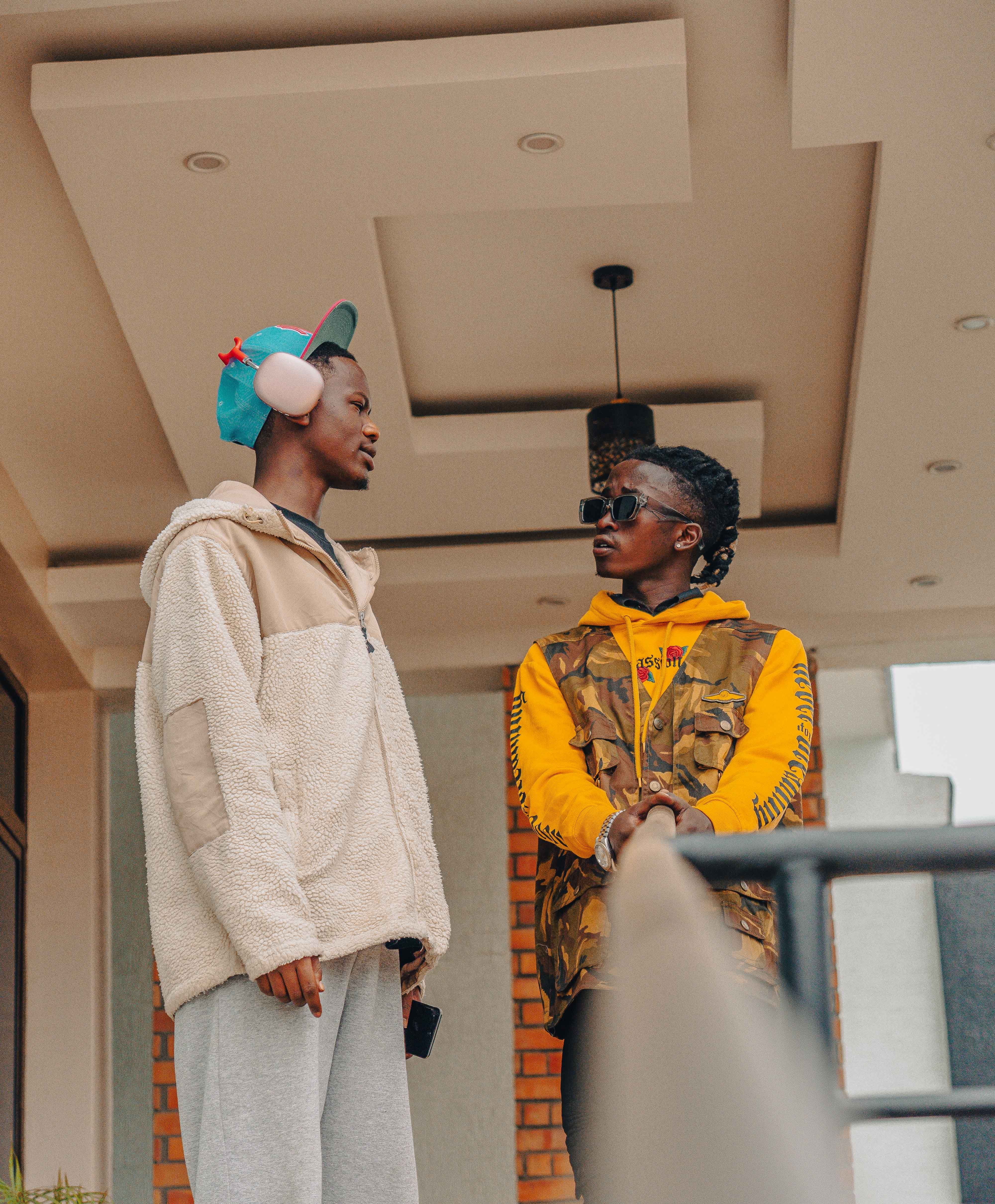 Two friends engage in a casual conversation while wearing trendy outfits indoors.