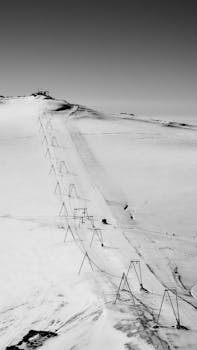 Black and white photo of a cableway on snowy terrain in Zermatt, Switzerland.