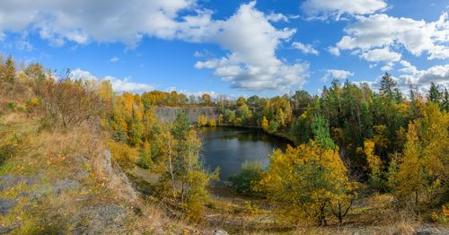Free A picturesque autumn landscape featuring a serene lake surrounded by vibrant fall foliage. Stock Photo