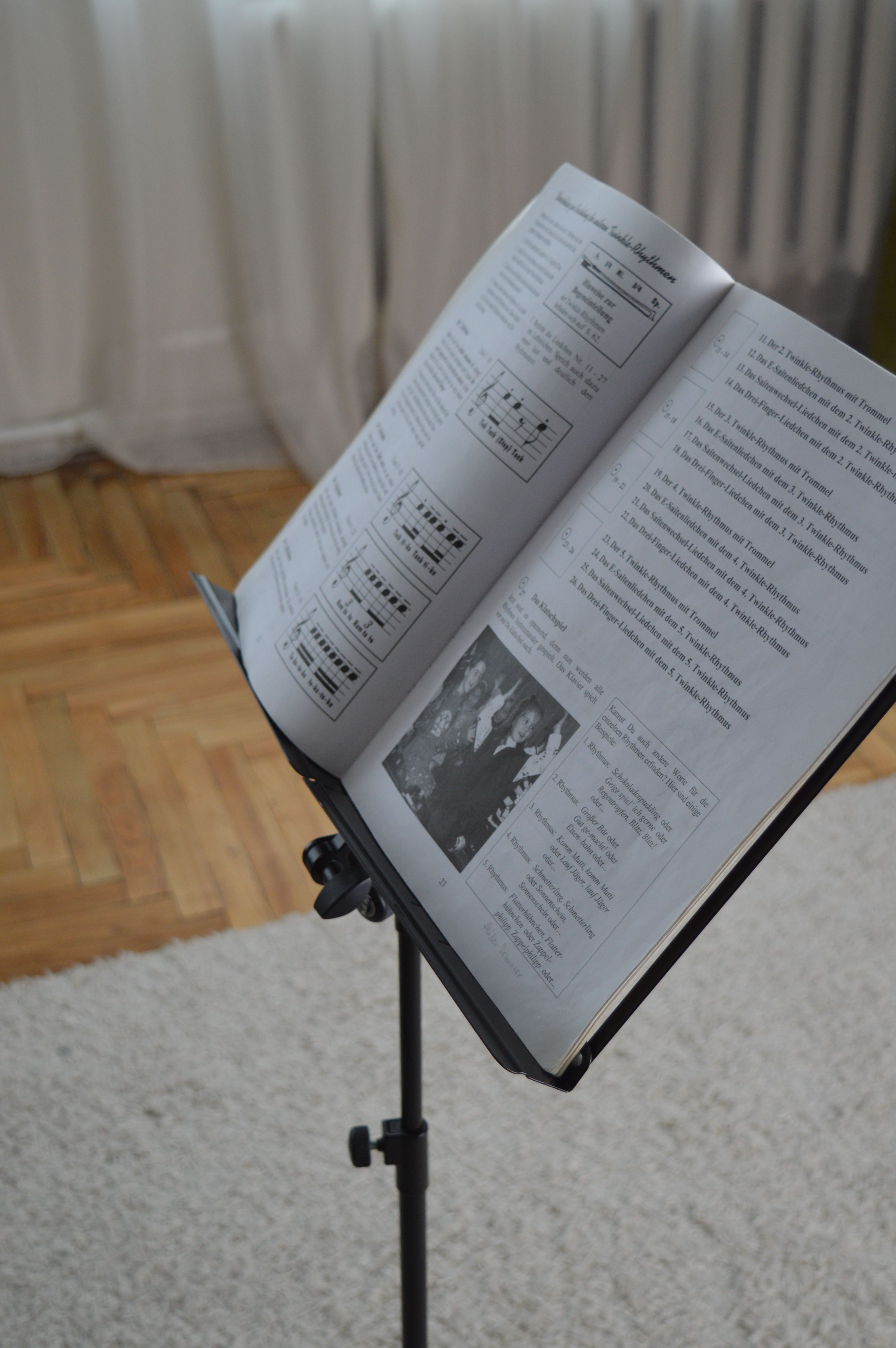Photo of an open music book on a stand indoors, suitable for educational purposes.