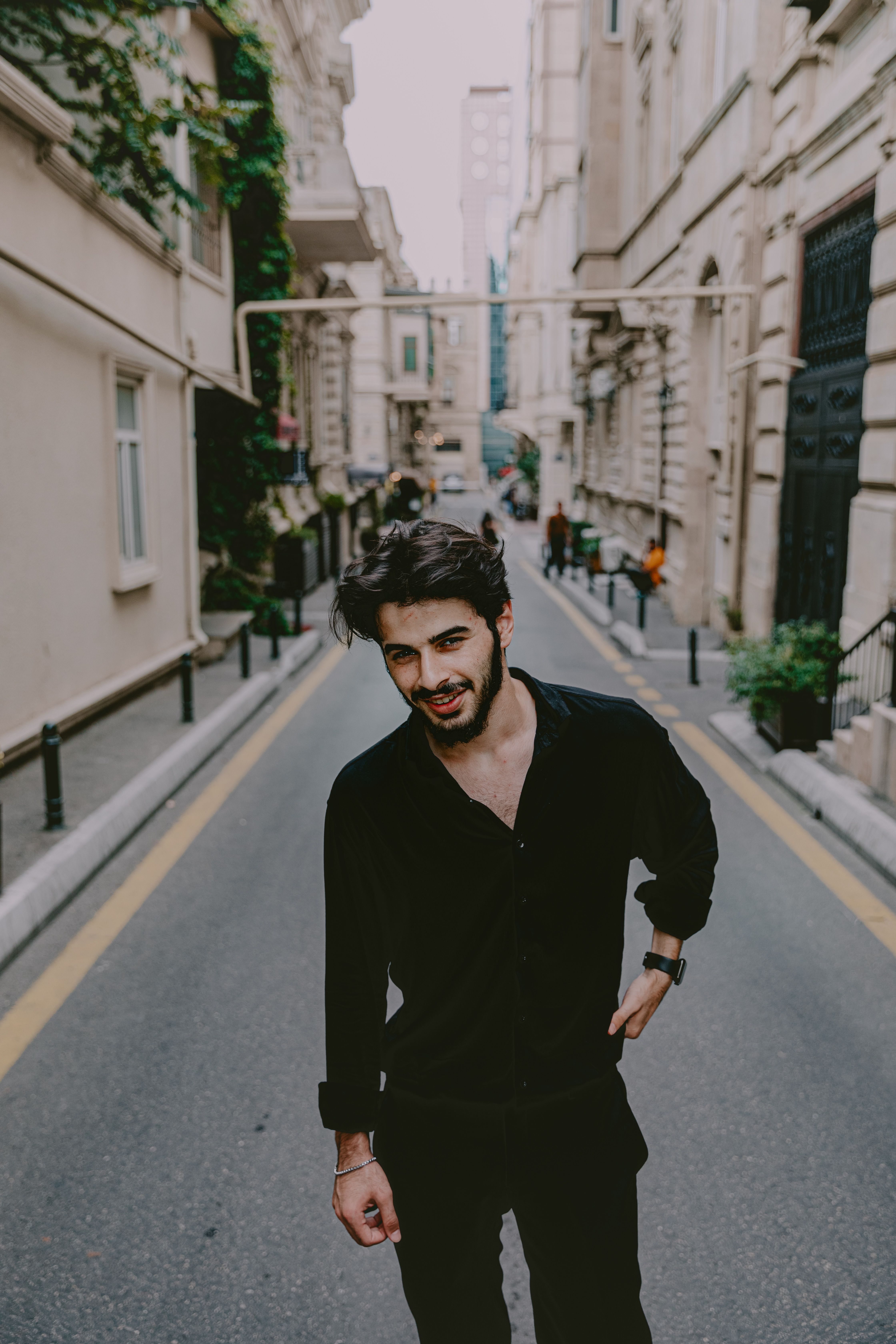 Portrait of a stylish young man in a trendy outfit on a vibrant street in Baku, Azerbaijan.
