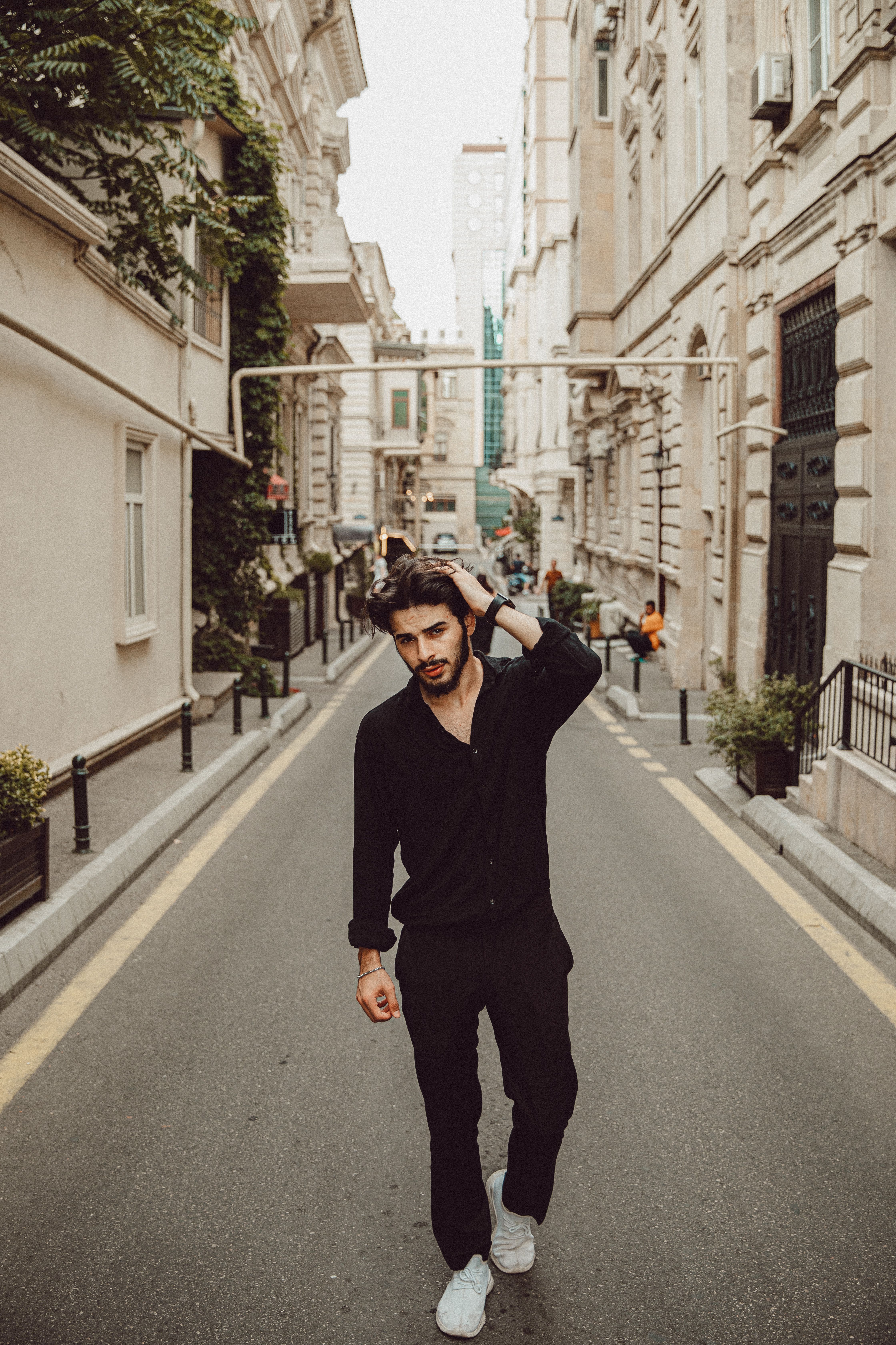 A fashionable young man walking down a historic street in Baku, Azerbaijan.