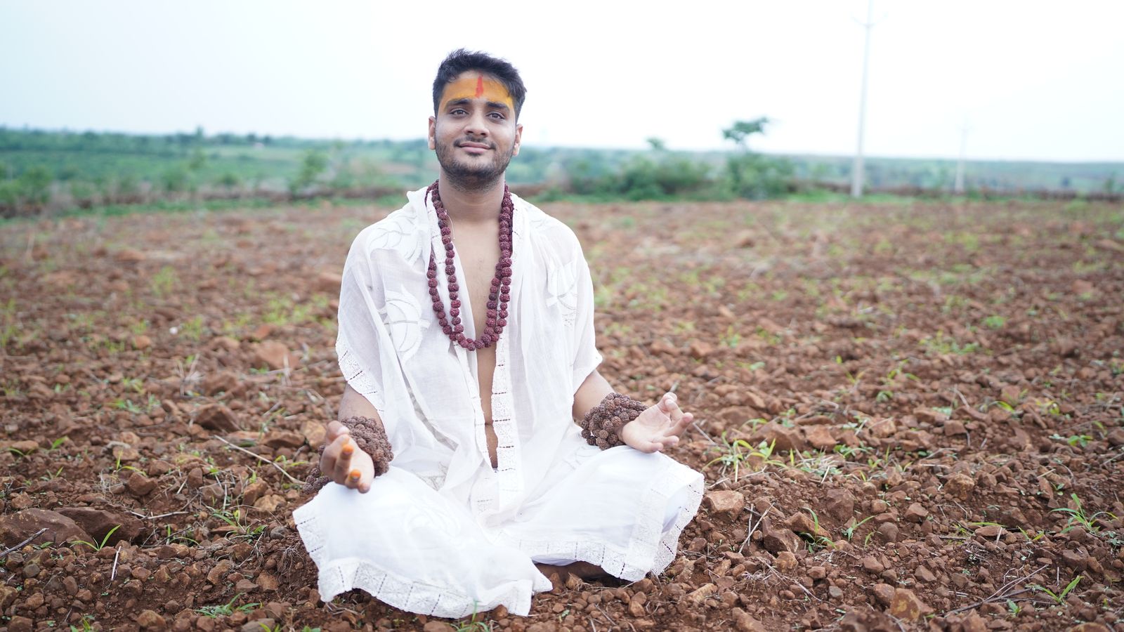 Woman sitting in meditation pose practicing the elements of yoga outdoors