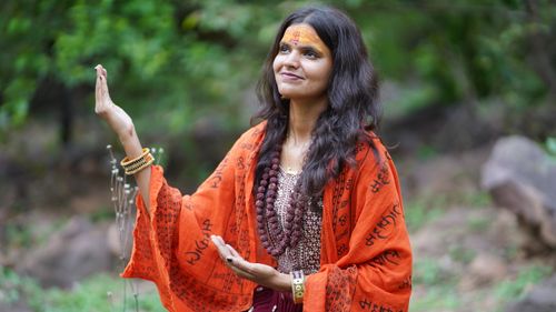 Free A woman in traditional attire meditating peacefully in a natural setting. Stock Photo