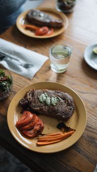 Delicious steak with vegetables served on a rustic table setting, perfect for a gourmet meal.