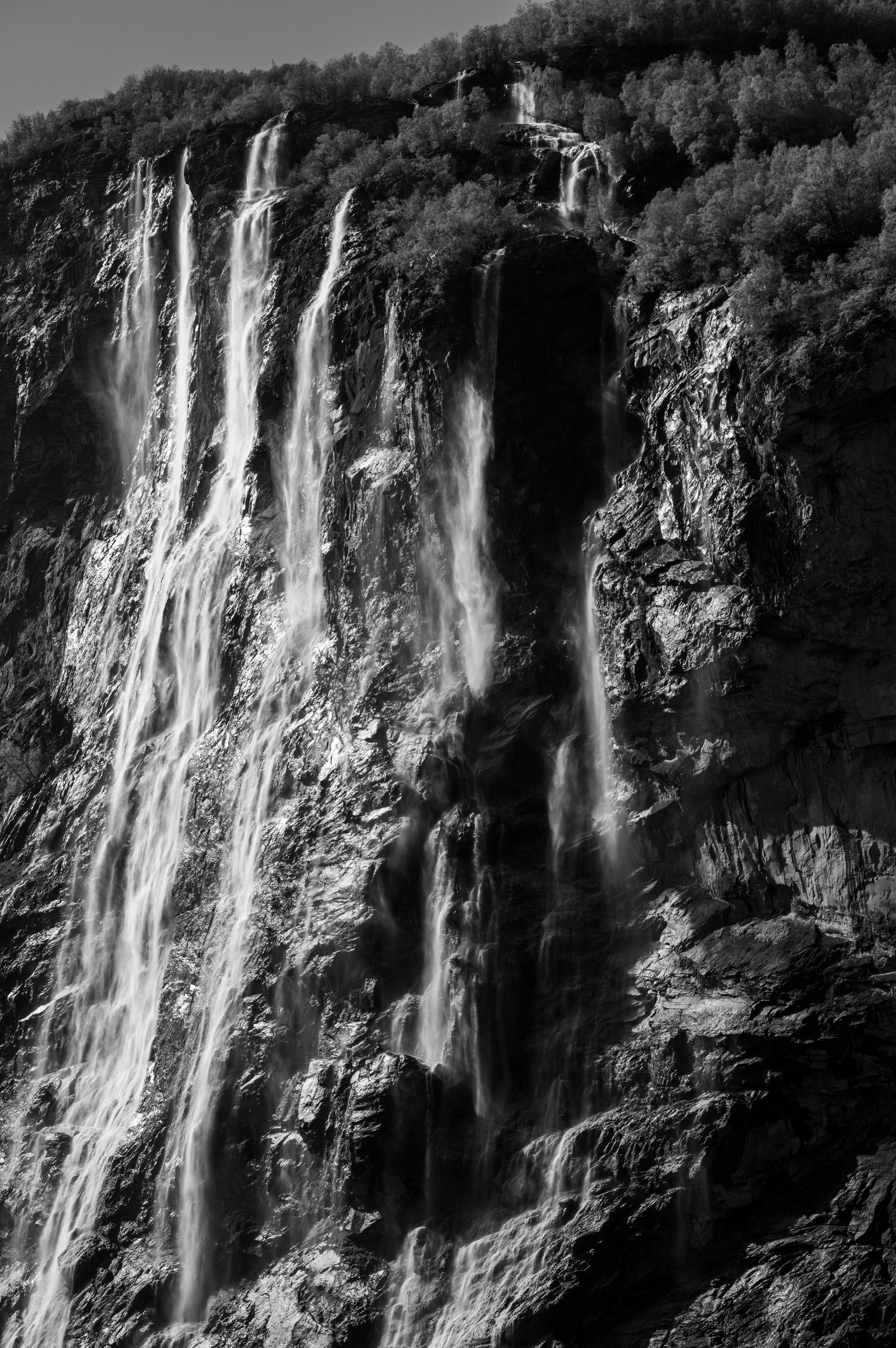 Stunning black and white waterfall in Geiranger Fjord, Norway, capturing nature's power.