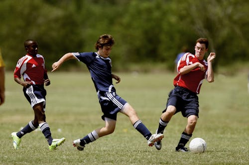 Free Three Men Playing Soccer Stock Photo