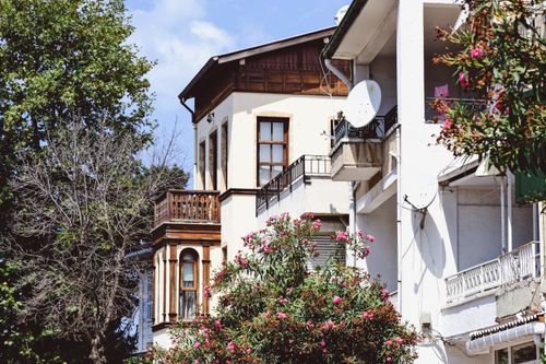 Free Explore the architectural beauty of traditional houses on Büyükada, İstanbul, with vibrant flowers and clear skies. Stock Photo