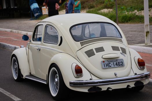 Vintage Volkswagen Beetle parked on street in Tôrres, Brazil, showcasing classic design.