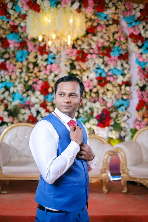 Free Groom looking dapper with a floral backdrop at an Indian wedding ceremony. Stock Photo