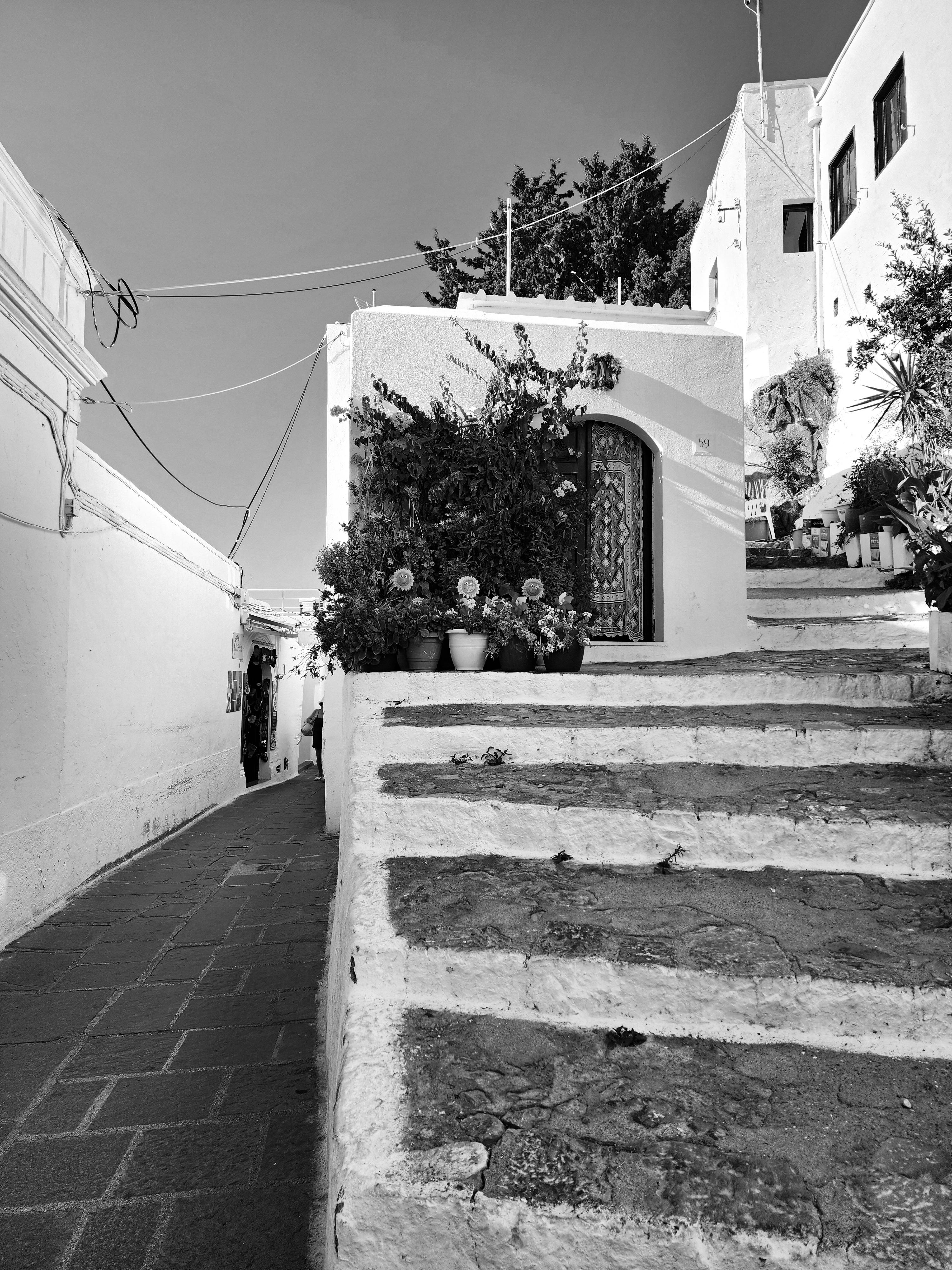 Explore the rustic beauty of Lindos, Greece, captured in stunning black and white photography.