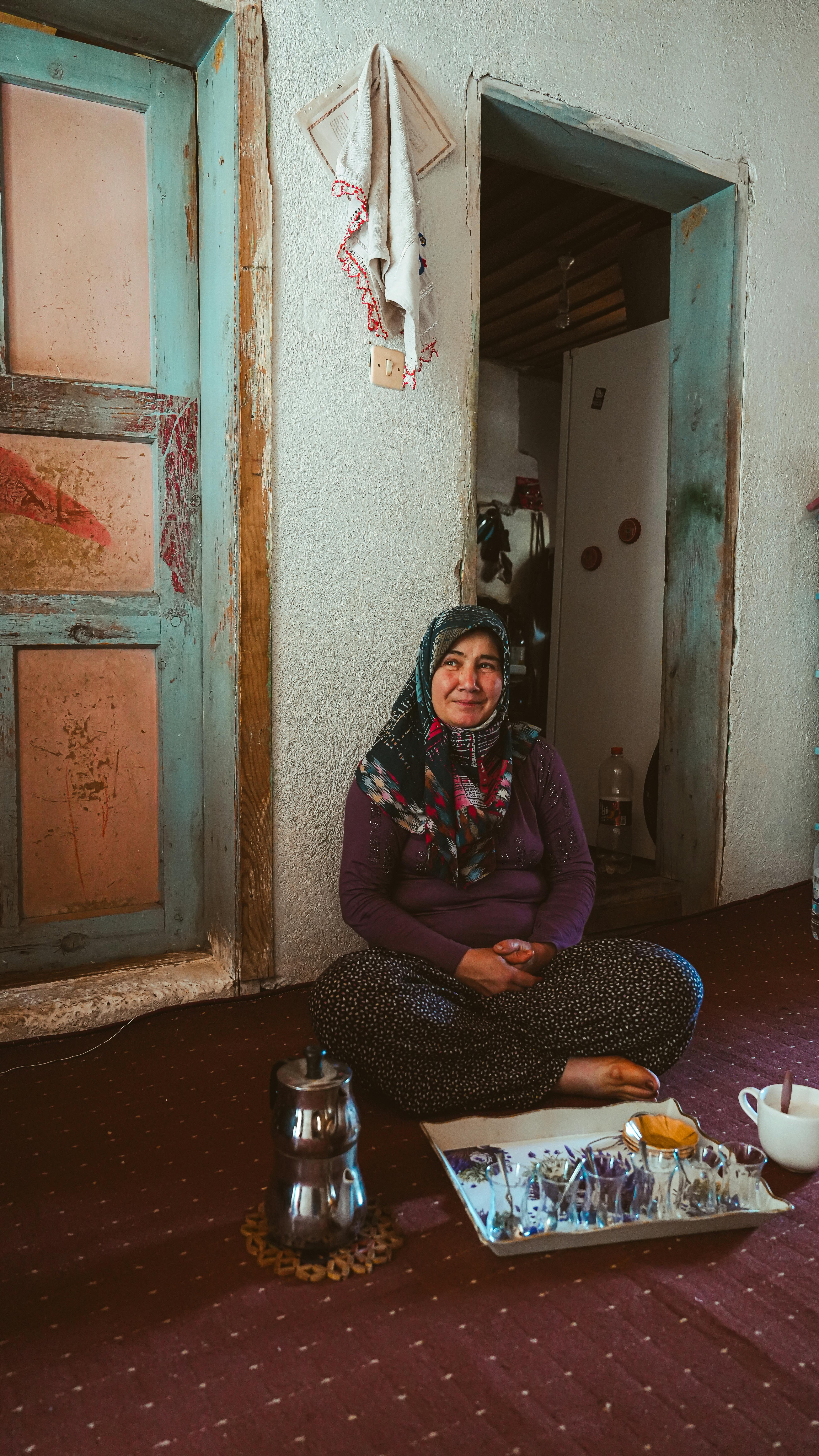 a woman sitting on the floor in front of a table