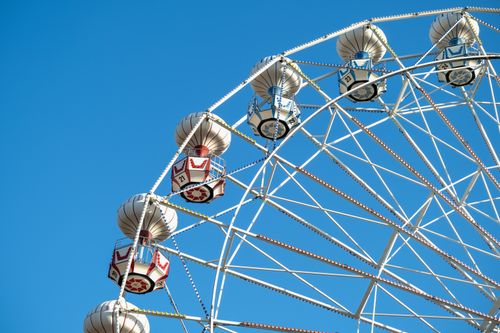 Free A vibrant Ferris wheel captures the essence of fun under a clear blue sky, symbolizing leisure and amusement. Stock Photo