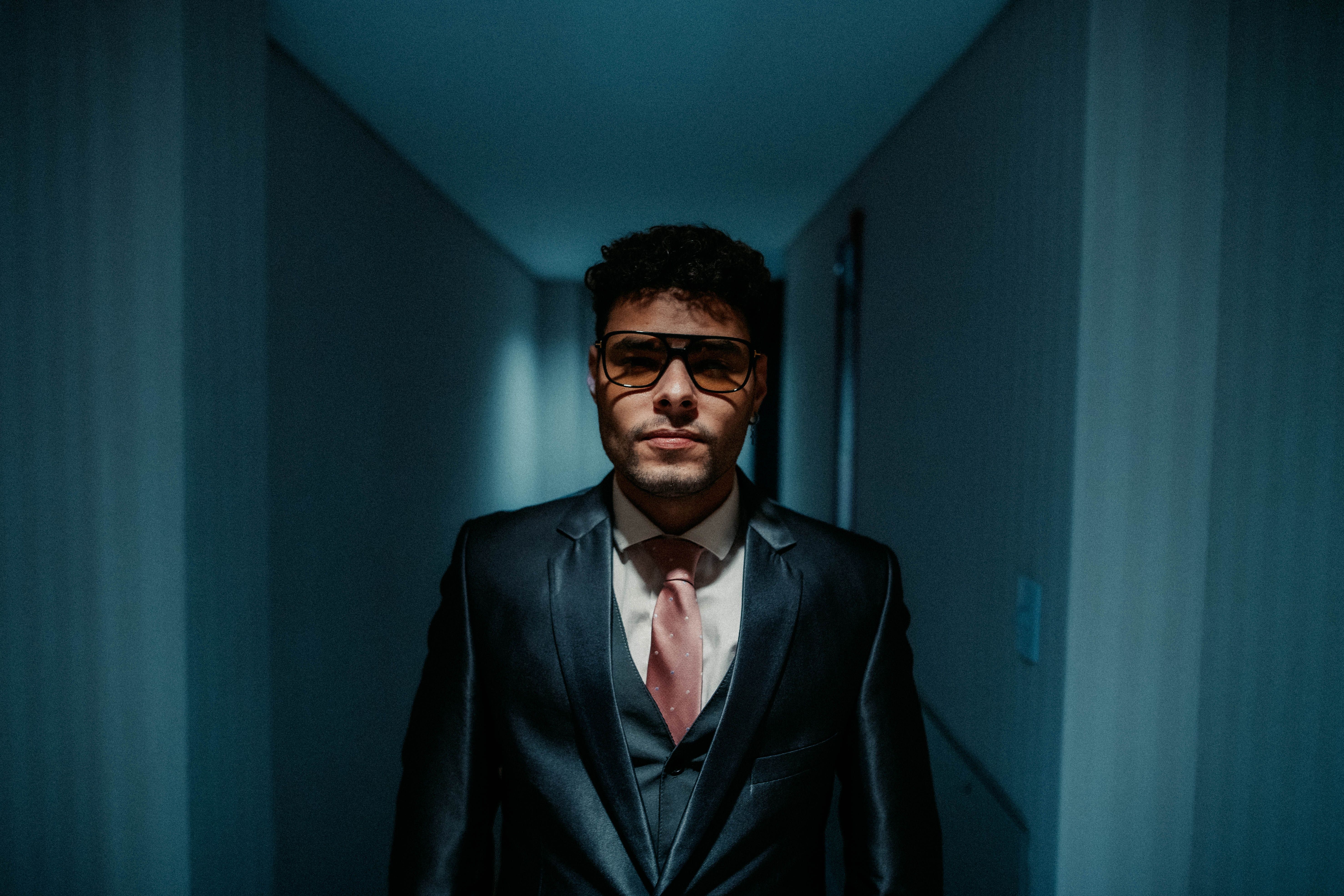 A man in a suit and tie standing in a hallway · Free Stock Photo