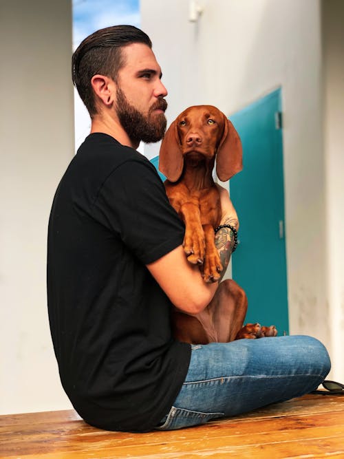 Free Man Carrying His Dog Stock Photo