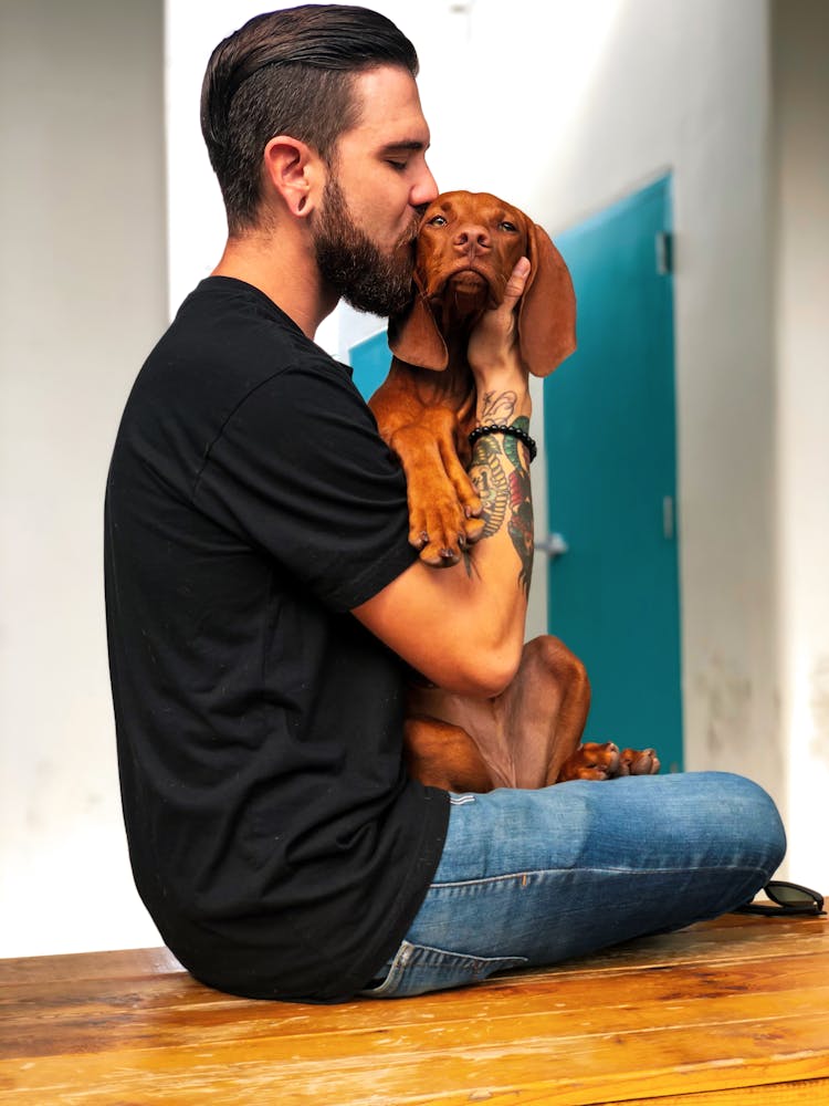 Photo Of Man Kissing His Dog