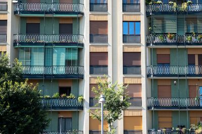Apartment-style hotel facade with glass balconies and planted terraces. Photo by Andrew Patrick Photo on Pexels