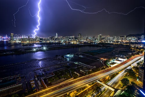Zeitrafferfotografie Von Blitzen über Beleuchteten Gebäuden Während Der Nacht