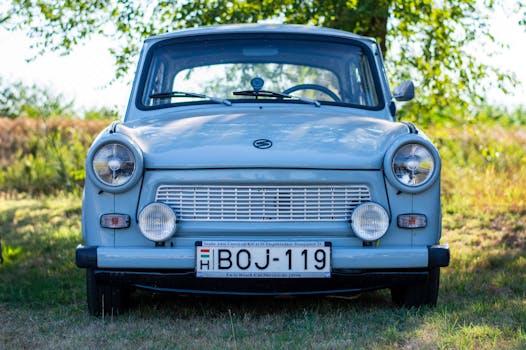 A classic vintage car parked outdoors, showcasing its iconic front design under sunny skies.