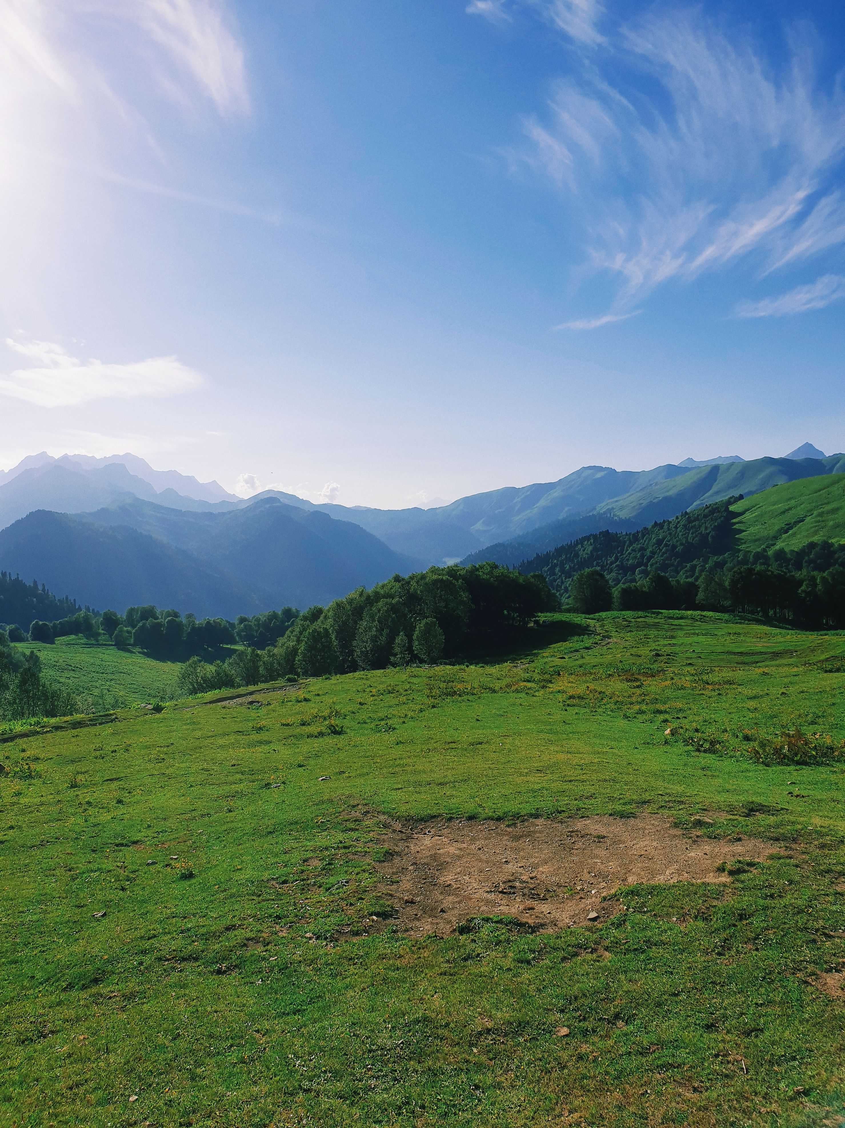 A grassy field with mountains in the background · Free Stock Photo