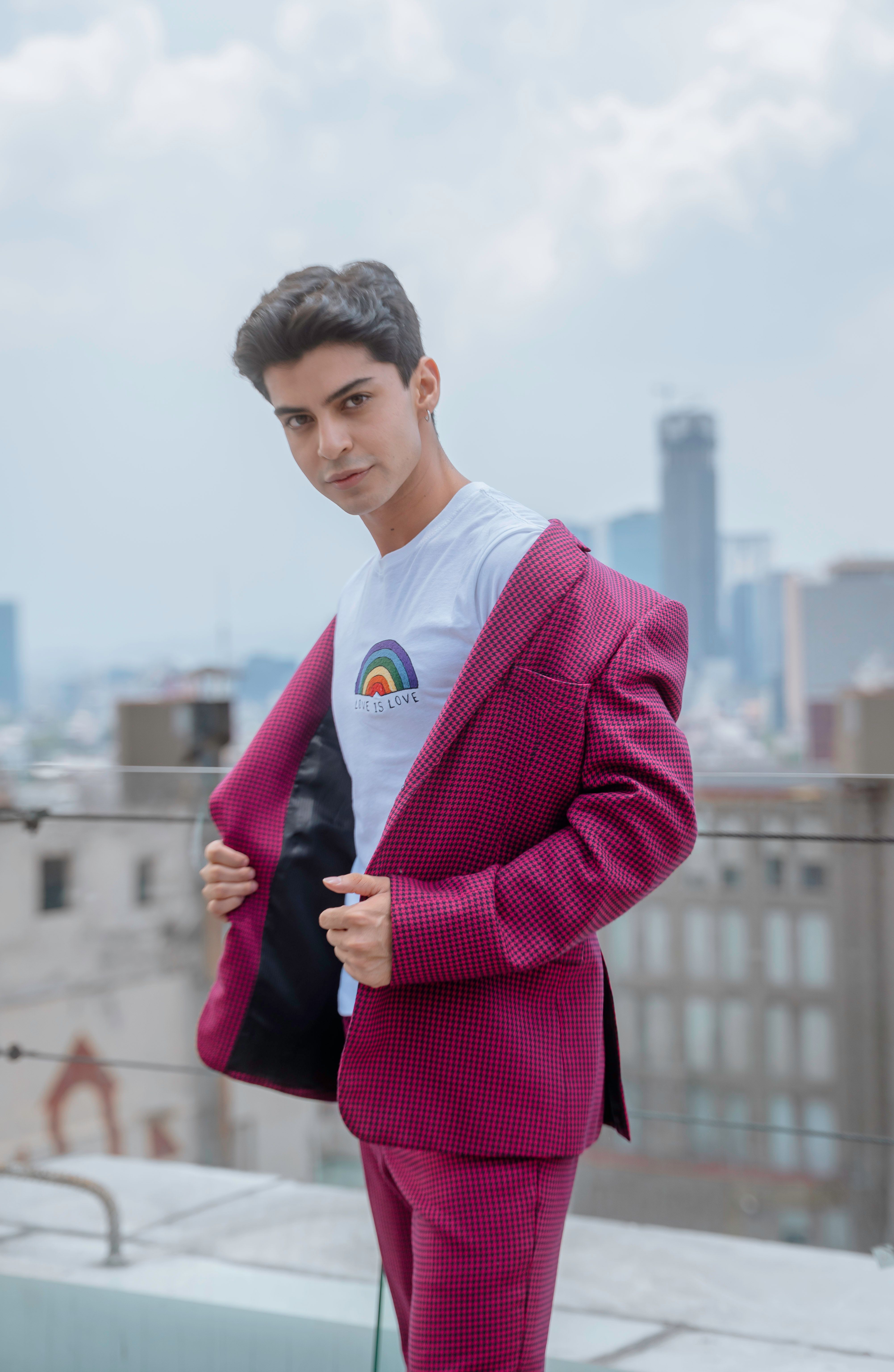 Young man in a vibrant outfit posing on a rooftop in Ciudad de México.