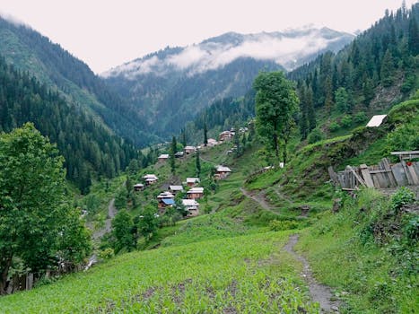 Idyllic village in Sharda nestled among lush green hills and misty mountains.