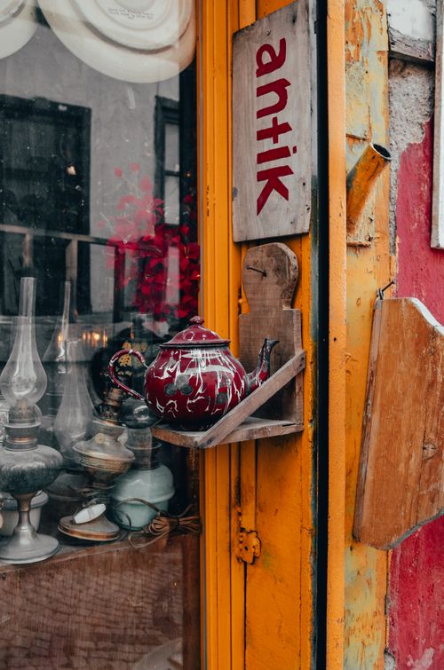 Free Colorful vintage shop with antique teapot and vibrant orange door, evoking nostalgic charm. Stock Photo
