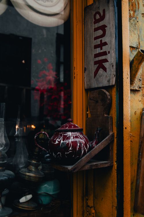 Free Rustic antique shop exterior with vintage teapot display and wooden signage. Stock Photo