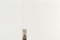 A white room with a door and a person standing in it