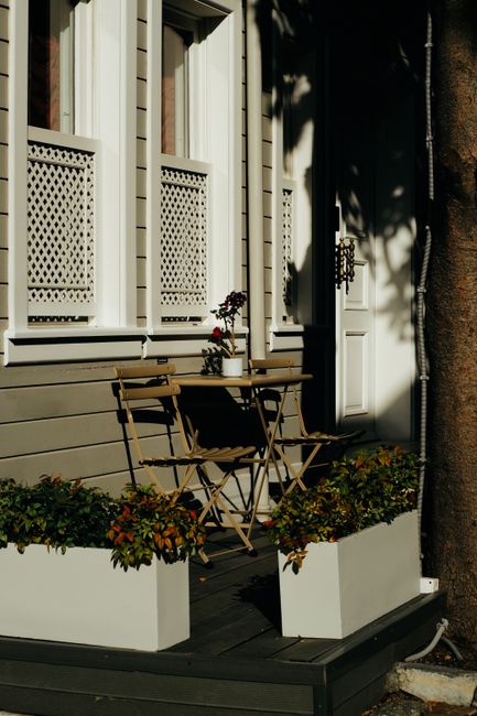Rustic outdoor café setting with wooden chairs and plants in İstanbul.