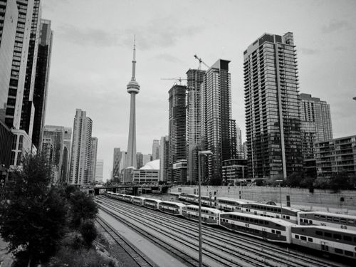Free Black and white cityscape of Toronto with CN Tower, skyscrapers, and train tracks. Stock Photo