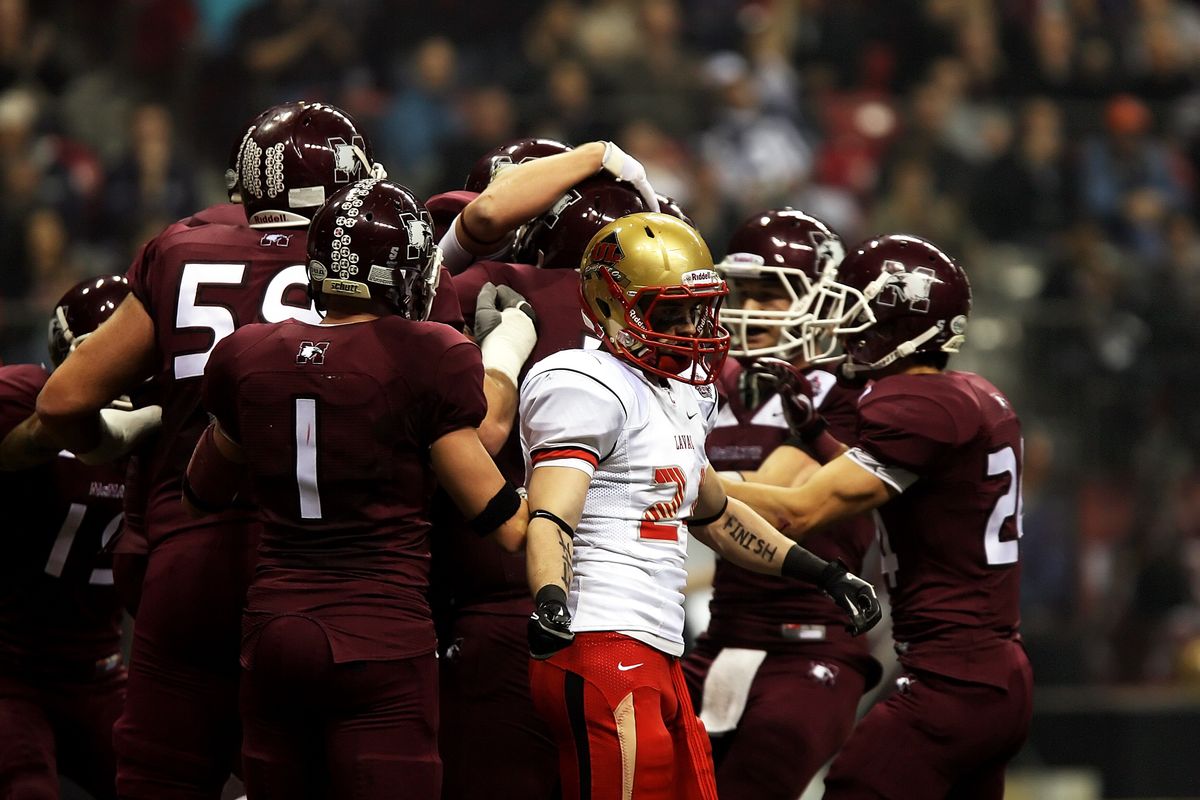 A football team huddled together on the field between plays.