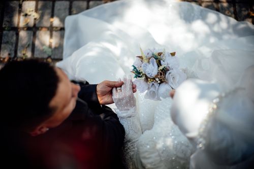 Free An intimate overhead view capturing a bride and groom during their wedding ceremony, featuring a beautiful bouquet. Stock Photo