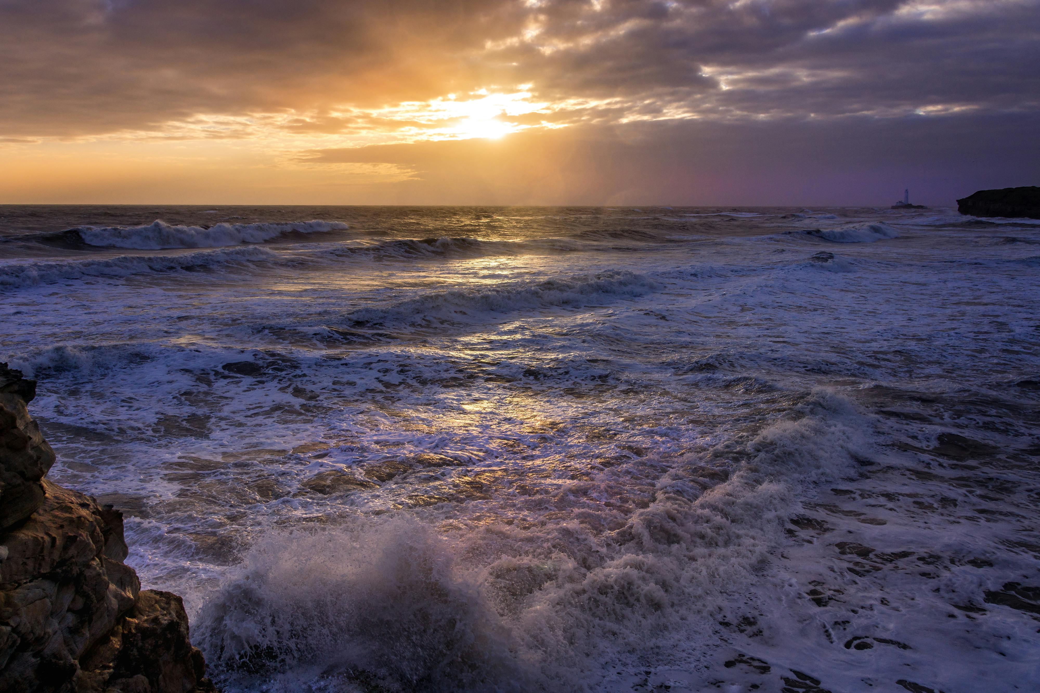 Waves Splashing at Stones on Beach during Sunset · Free Stock Photo