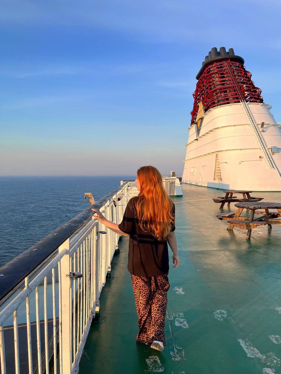 Single traveler enjoying a walk on a cruise ship deck at sunset