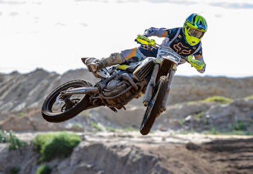 A motocross rider performs an impressive jump at a dirt track in Cape Town. Action and skill captured mid-air.