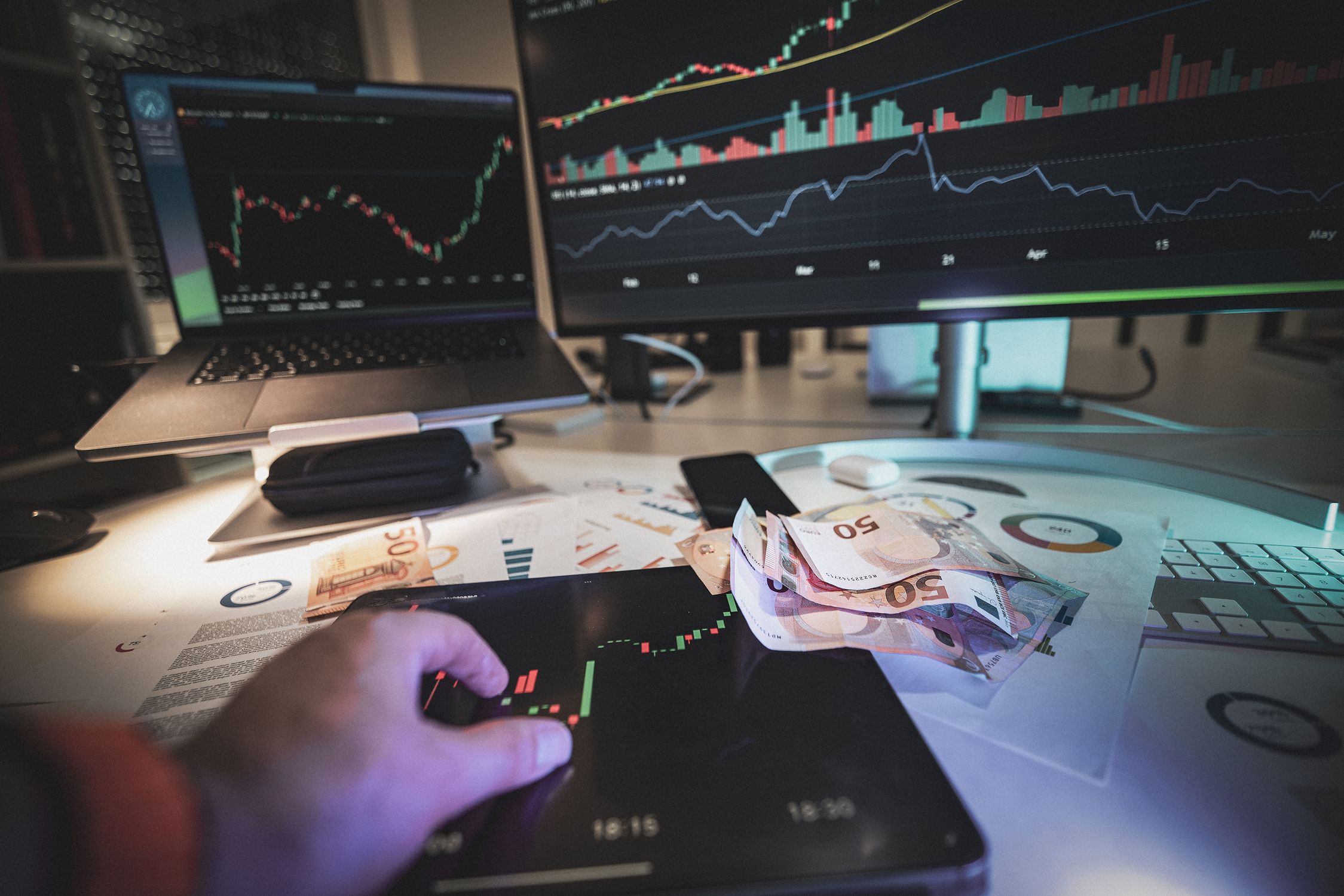 Hand on tablet showing forex market quotes and euro currency notes representing FX swap rates
