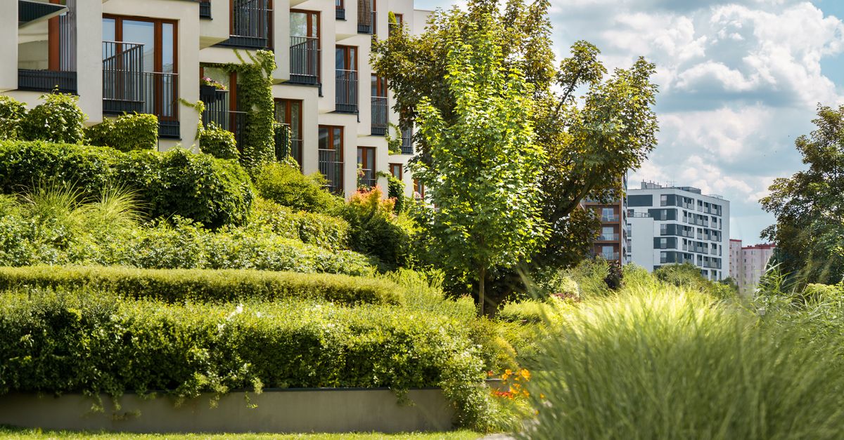 Elegant modern residential complex with lush gardens and urban landscape views.